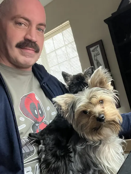 Jonathan Heavner holding his two Yorkies.